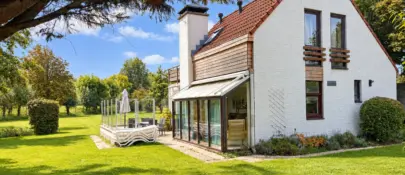 Zonnige tuin met modern landhuis