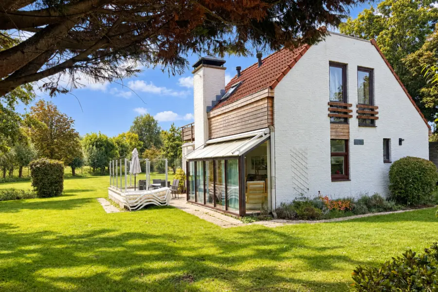 Zonnige tuin met modern landhuis
